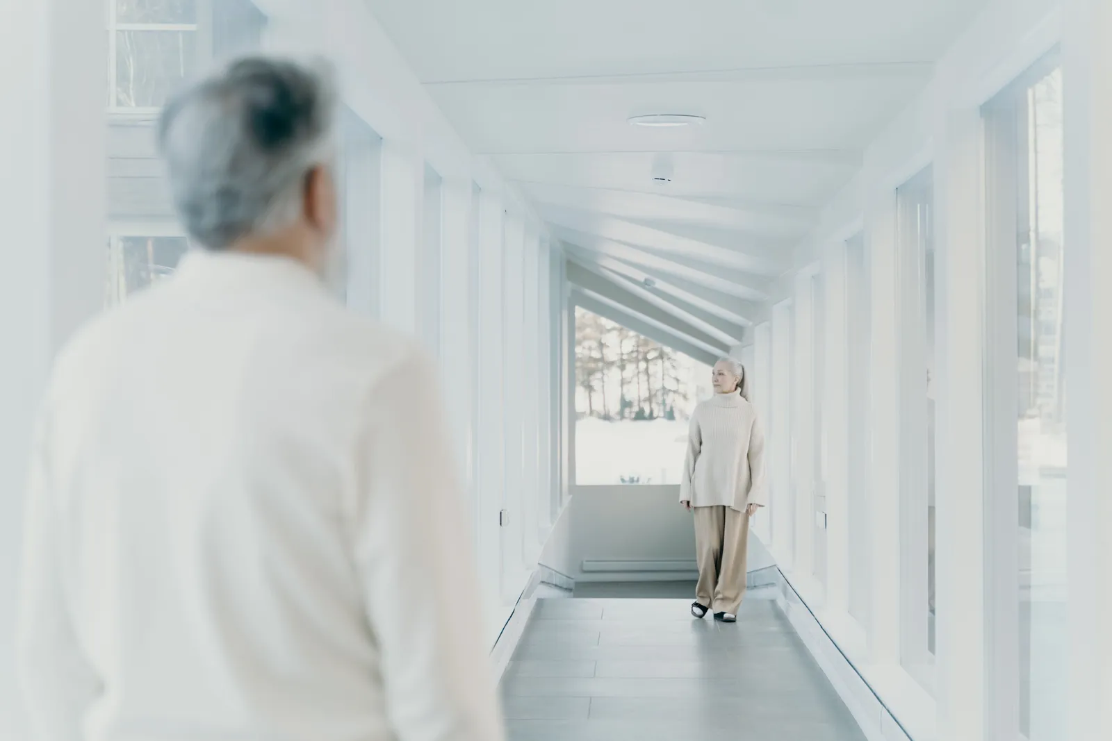 Older adult walking along a bright hallway at a normal pace